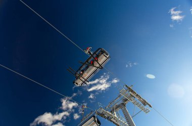 Güneşli bir günde kayak kaldıran kayakçılar