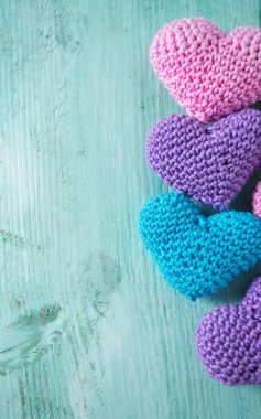 turuoise ahşap yüzeyde örme kalpler