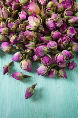 Turkuaz ahşap yüzeyde kurumuş gül tomurcukları