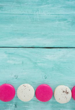 ahududu ve vanilya macaroons turkuaz ahşap yüzey üzerinde