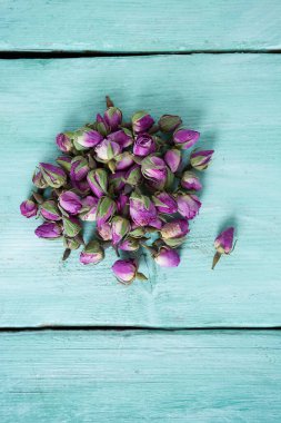 Turkuaz ahşap yüzeyde kurumuş gül tomurcukları