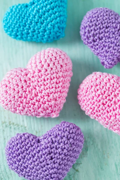 turuoise ahşap yüzeyde örme kalpler