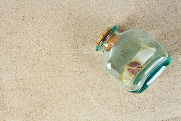 message in a bottle on sea sand