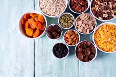 Tahta yüzeyde çeşitli tahıllar, fındıklar ve kurutulmuş meyveler.