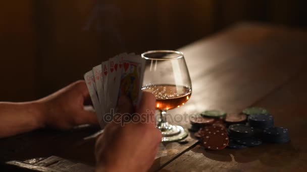 Distribuzione di carte in un poker sul tavolo con un sigaro e whisky — Video Stock