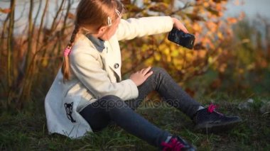Genç bir kız bir selfie sonbahar ormanda yapar.