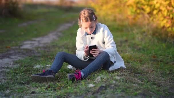 Молодая девушка делает селфи в осеннем лесу — стоковое видео