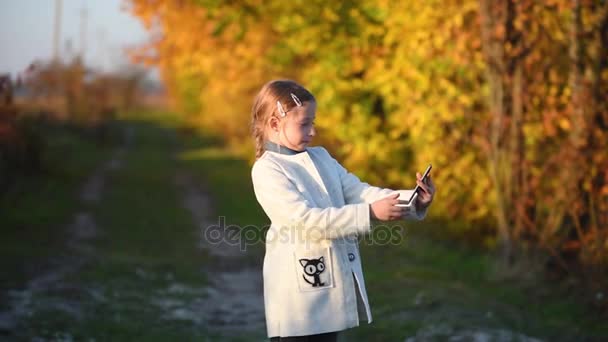 Μια νεαρή κοπέλα κάνει μια selfie στο δάσος το φθινόπωρο — Αρχείο Βίντεο