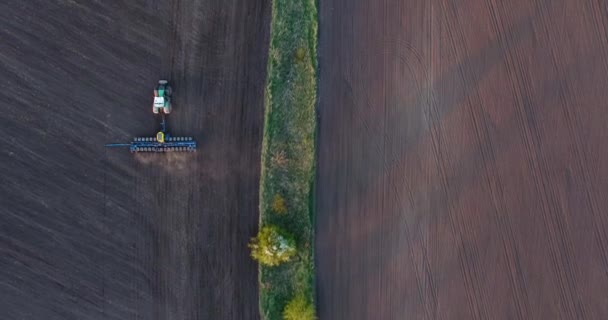 Vue du dessus d'un tracteur plantant du blé au coucher du soleil — Video