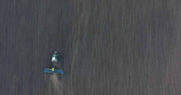 Blick von oben auf einen Traktor, der bei Sonnenuntergang Weizen pflanzt — Stockvideo