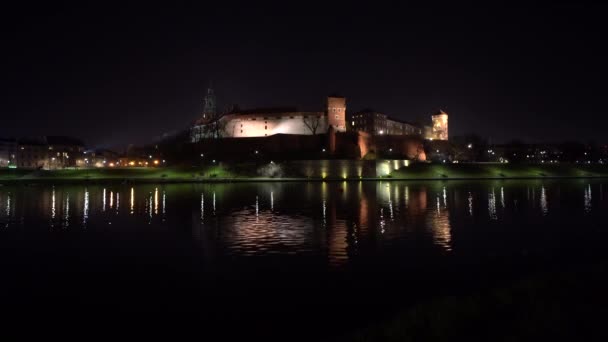 Castillo de Wawel Real iluminado por la noche reflejando en el río Vistula, Cracovia - Polonia 4K. — Vídeo de stock