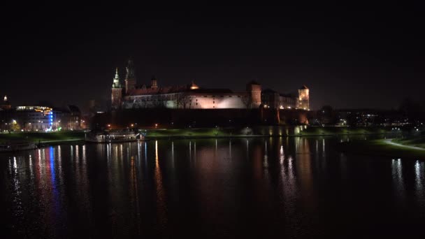 크라코프 - 폴란드 4K 의 비스툴라 강에서 밤에 반사되어 비텔라 강을 반사하는 왕실와 벨 성 — 비디오