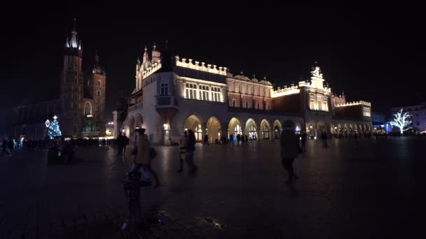 Cracovia Polonia Mercado de Navidad en la plaza principal de Cracovia lleno de gente, luces y nieve 4K — Vídeos de Stock