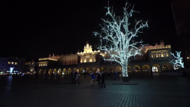 Cracóvia Polónia Mercado de Natal na praça principal de Cracóvia cheio de pessoas, luzes e neve 4K — Vídeo de Stock