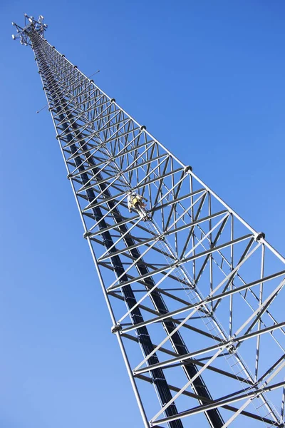 Escalador ascendiendo a la torre celular — Foto de Stock