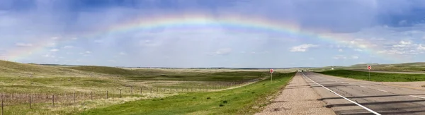 Regenboog boven de weg in Saskatchewan — Stockfoto