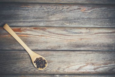 Farklı baharatlar ve tuz ahşap bir masada, tahta kaşıklarda yatıyor.