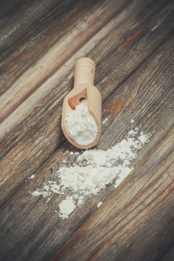 Ekmek pişirmek için un ve buğday başakları ahşap bir yüzeyde yatar.