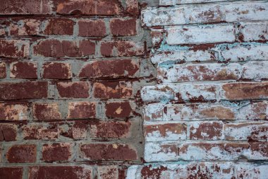 Üzerinde çizikler ve aşınma olan eski kırmızı tuğla bir duvar..