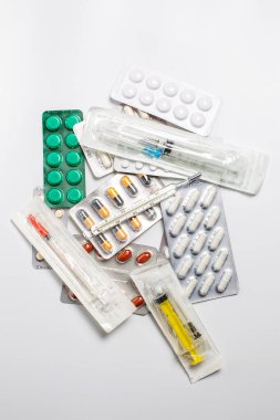 Enjeksiyon için şırınga, termometre ve hastalıklar için çeşitli haplar.
