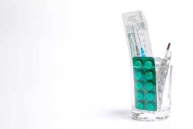 Hastalıklar için çok farklı ilaçlar şırınga ve bir bardakta tedavi için termometre.