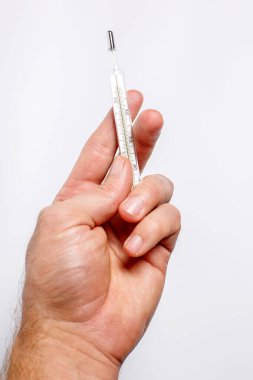 Kişinin elinde vücut ısısını ölçmek için termometre