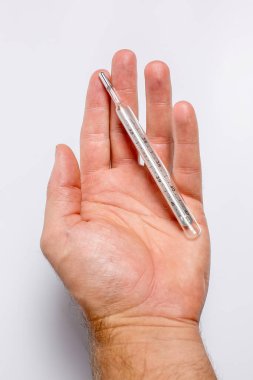 Kişinin elinde vücut ısısını ölçmek için termometre