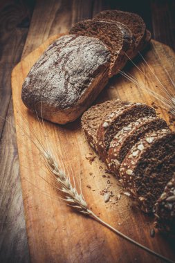 Güzel kokulu, taze ve lezzetli siyah ekmek, dikenleri ve tahılları olan eski bir yüzey.
