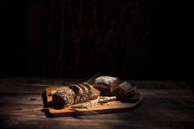 Güzel kokulu, taze ve lezzetli siyah ekmek, dikenleri ve tahılları olan eski bir yüzey.