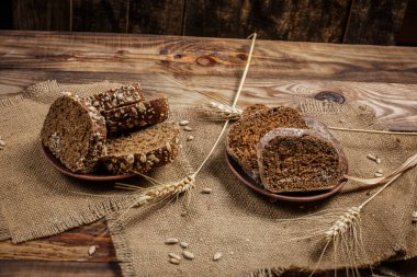 Güzel kokulu, taze ve lezzetli siyah ekmek, dikenleri ve tahılları olan eski bir yüzey.