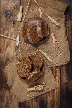 Güzel kokulu, taze ve lezzetli siyah ekmek, dikenleri ve tahılları olan eski bir yüzey.