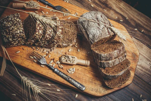 Güzel kokulu, taze ve lezzetli siyah ekmek, dikenleri ve tahılları olan eski bir yüzey.