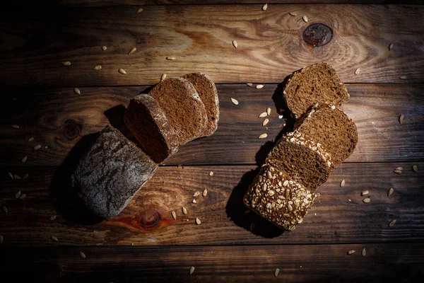 香喷喷的 美味的黑面包就在古老的表面上的小穗和种子旁边 — 图库照片