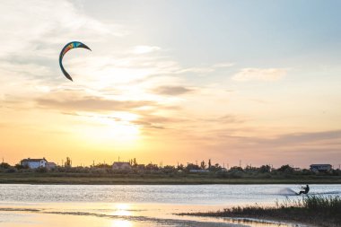 Güzel bir gün batımında denizde uçan bir atlet..
