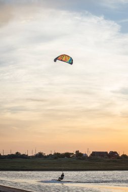 Güzel bir gün batımında denizde uçan bir atlet..