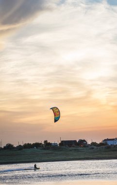 Güzel bir gün batımında denizde uçan bir atlet..