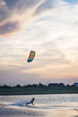 Güzel bir gün batımında denizde uçan bir atlet..
