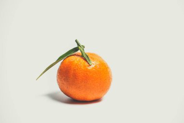 Beyaz arka planda yeşil yapraklı turuncu renkli tatlı mandalinalar.