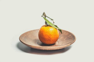 Beyaz arka planda yeşil yapraklı turuncu renkli tatlı mandalinalar.