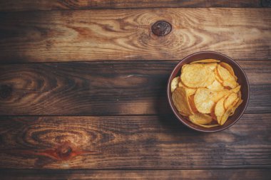 Tahta masadaki farklı baharatlı cipsler.