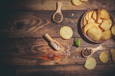 Tahta masadaki farklı baharatlı cipsler.