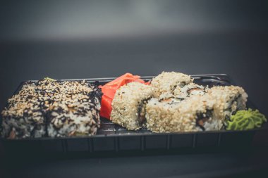 Koyu wasabi soslu ve wasabi soslu farklı Asya suşisi.