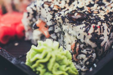 Koyu wasabi soslu ve wasabi soslu farklı Asya suşisi.