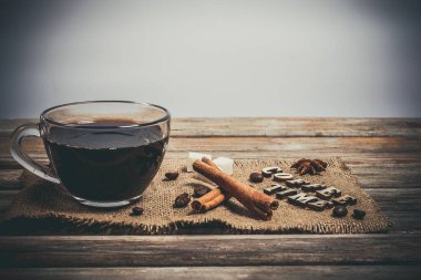 Cam bardakta Aromatik Lezzetli kahve ve eski kahverengi arka planın yanında tarçın.