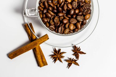 Kahve taneli fincan, beyaz arka planda tarçın.