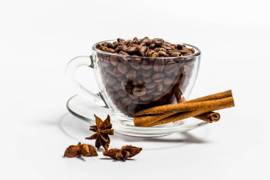 Kahve taneli fincan, beyaz arka planda tarçın.