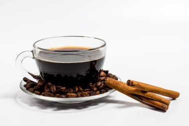 Cam bir fincanda Aromatik lezzetli kahve ve beyaz arka planın yanında tarçın.