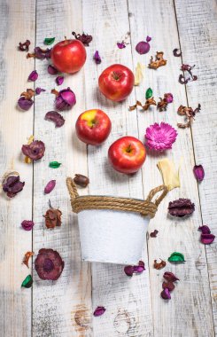 Güzel kırmızı elmalar beyaz arka planda çiçekli ve beyaz kovada