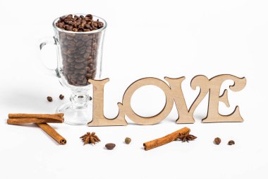 Beyaz arka planda bir bardak sıcak şarap ve kahve taneleri.