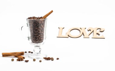 Beyaz arka planda bir bardak sıcak şarap ve kahve taneleri.